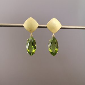 Weißer, quadratischer Ohrstecker an dem ein Peridot hängt.
